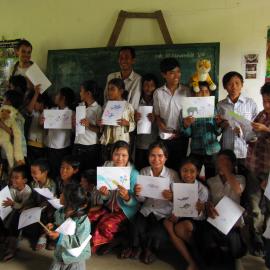 School children hold up their drawings of forest wildlife as part of the awareness raising campaign.