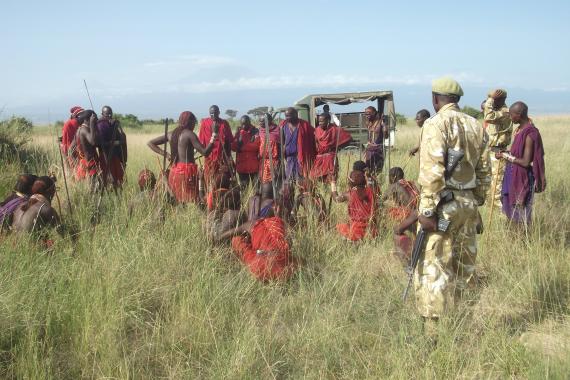 Members of the Maasai communities are employed as community scouts and are gathered around.